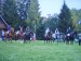 Koně a jezdci seřazeni u chatek v campu